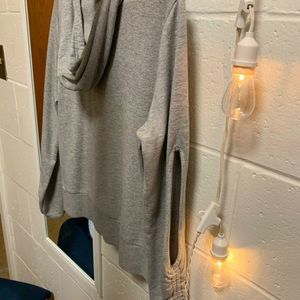 Thin/soft grey hoodie with slits in the elbows.